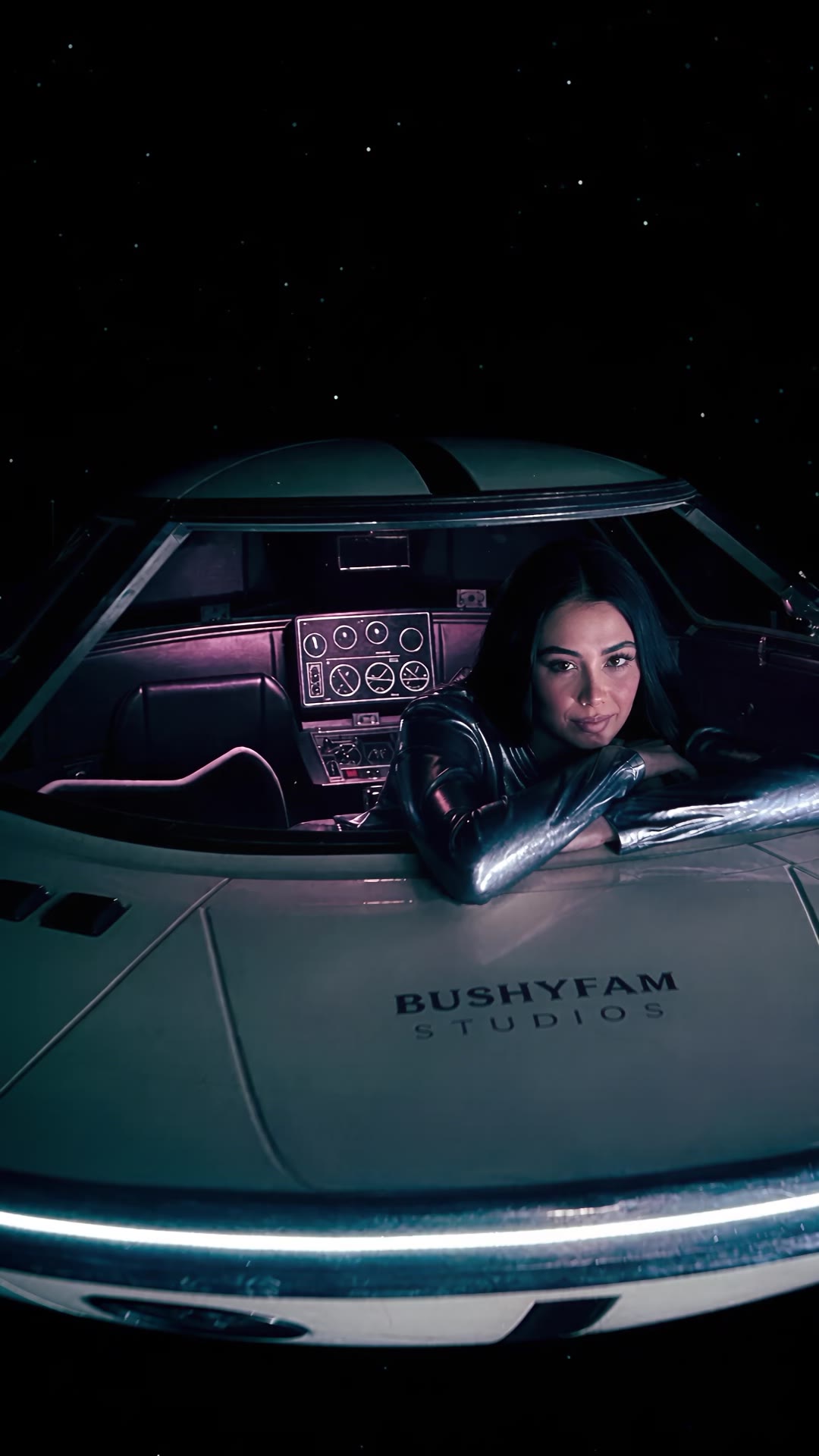 Kısa film: bir kadın BushyFam yazılı bir UFO kokpitinden dışarı bakıyor; kamera onun gözbebeğinin içine kadar ilerliyor.